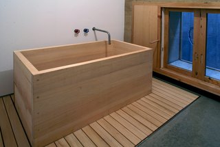 The bathtub is a simple box made of fragrant hinoki cypress. Its shape echoes one of Cho’s favorite inspirations: a wooden apple crate.
