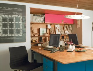 The architectural office below the living quarters is compact, with just enough space for shared workstations and a bookcase made of plywood and pink Plexiglas.