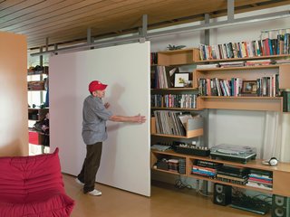 Molina and Turin combined angle and bar aluminum from Industrial Metal Supply Company and wheels from Pro-Fit Cabinet Hardware to design a custom track for a sliding door/projection screen fashioned out of two hollow-core doors from Stock Building Supply Company.