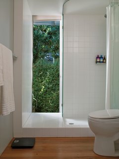 At $2.75 a square foot (which includes a designer discount), Molina and Turin could afford to extend matte white ceramic tiles from Dal-Tile beyond the conventional shower boundaries to give the bathroom the look of a brighter, more expansive space.