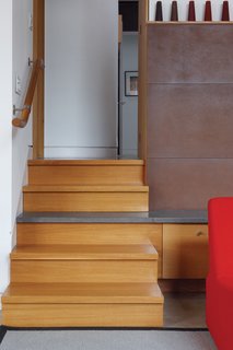A staircase leads up to the main bedroom; the stairs and the fireplace were designed by Fleming with the architects.