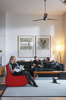 In the living room, Adams relaxes on a chair by designer Scot Laughton while Fleming plays banjo.