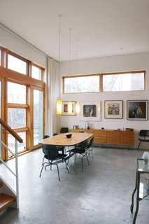 The dining room has a mishmash of Eames chairs, found in various states and painted black.