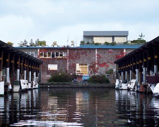 Atop a warehouse/office building overlooking Seattle’s Salmon Bay waterway, Tom Bayley’s home watches over a 250-slip marina. Few tenants below notice his presence, except when errant drops from his watering can fall from his deck, 25 feet above.