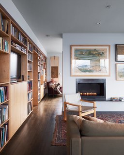 Bayley’s ventless fireplace from Spark Modern Fires keeps the house toasty as he reads in his favorite red armchair, a vintage-store find, in his bedroom.