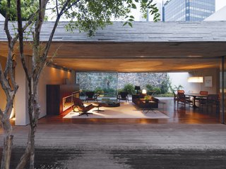 By keeping the front and back gardens at the same elevation as the living area, Kogan created one giant living space. A large overhang means that even on a rainy day, the Cósers can live practically without walls. The dining area is defined by a classic Oval dining table by Eero Saarinen for Knoll. Brazilian master designer Sergio Rodrigues did the matching pair of armchairs in the living room.