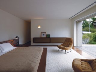 Kogan designed a number of the built-in furnishings, including the headboard and cupboard in the master bedroom.The cupboard is deliberately reminiscent of a mid-century stereo speaker. The vintage lounge chairs are by Percival Lafer.
