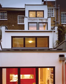 At the back, the building steps down to the courtyard garden in a ziggurat formation, with the main living spaces on the lowest floor.