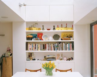 Throughout the house, built-in storage and shelving is cleverly positioned in alcoves and recesses, as in the dining area, which allows clutter to be easily cleared away.