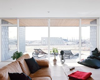 The living room receives ample light through the south-facing glass doors and floor-to-ceiling windows.