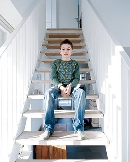 Axel sits on the staircase, which like all the internal and external cladding in the house is made from Douglas fir.