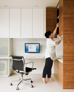An Eames Aluminum Group chair for Herman Miller and bamboo shelving system are featured in the office Camille Owens and architect husband Francisco created within their living-dining space.