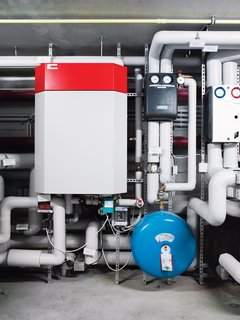 Here, in the basement, a borehole heat exchanger uses the warmth from the earth, brought to the surface by four steel pipes that reach 105 feet down, for heating. Solar panels heat the building’s water, and a clever ventilation system ensures that the glass house doesn’t get too warm in the summer.