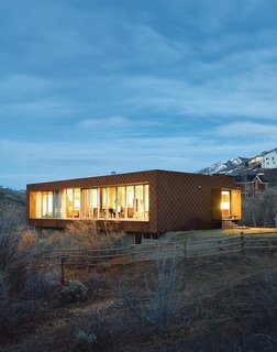 The First LEED for Homes–Rated House in Utah - Photo 4 of 10 - Mooney and Sparano’s house glows like a lantern against a backdrop of scrubby oaks, faux colonials, and "wannabe lodges" with more square footage but less eco-cred. The home’s northwest facade, facing the canyon and a 200-acre camp for individuals with disabilities, is glazed with sliding glass doors that open to merge indoors and out.