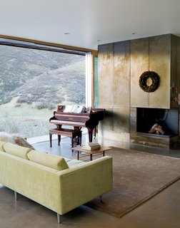 The First LEED for Homes–Rated House in Utah - Photo 5 of 10 - In the living room, the canyon vistas share center stage with the wood-burning fireplace (attractive despite going through an "awkward phase") and a rare quarter-grand piano from the late 1800s, a Mooney family heirloom. The polished concrete floors are radiant-heated, powered by a small, highly efficient boiler in the basement.