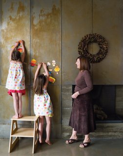 The First LEED for Homes–Rated House in Utah - Photo 1 of 10 - In the living room, Claire and Audrey demonstrate the magnetic quality of their fireplace by hanging artwork next to the wreath.