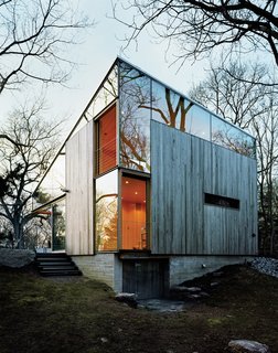 Sheets of unframed glass fill the spaces between the building’s operable windows and the sloping eave of the roof, giving the house, as architect Alan Organschi puts it, "the feel of coming apart at the seams—of surfaces unhinged."
