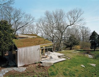 The deck, fashioned from ipe, was built around one of the property’s many granite outcroppings. An earthen roof was planted with the same varieties of sedum that were added to the front of the cottage.