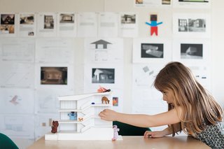 Zoë plays with a model in the office.