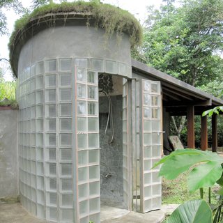 An outdoor shower in Costa Rica constructed by green homebuilder B-green Homes utilizes a mechanism for French doors from nearly two centuries ago that's sturdy enough to withstand the weight of glass block. The result is a unique shower with a grand entryway that lets natural light filter through.