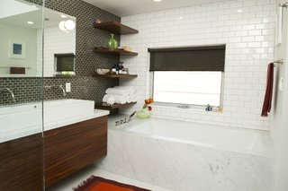 Misra notes that in the master bath, "Elizabeth and Edgar wanted a muted palette." This was achieved with white subway tile and a smaller brown tile from Interceramic that echoed the larger-scale tile. "We saw the little Jasper Morrison ball lights in London and then couldn’t find them again," says Lyall. "We finally came across them at a store on Melrose in LA, and bought them after obsessing over them for awhile." The fixtures are by Rohl; the sink is from Duravit.