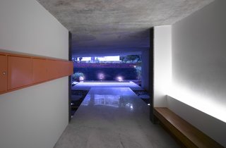 A Modern Aesthetic in Mumbai - Photo 9 of 17 - Looking back from the lobby area toward the street; the sidewalk is just beyond the wall at rear. At right is a bench for the residents; at left are the mailboxes, for which Khanna and Schultz chose a bright orange. The pair worked with Forethought Design Consultants on the landscaping, which will eventually grow more lush and provide additional privacy. "In this climate, within a year, it will be completely filled in," says Schultz.