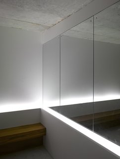A Modern Aesthetic in Mumbai - Photo 10 of 17 - A mirror near the mailboxes in the lobby gives the illusion of more space. A team from Lighting Planners Associates, based in Japan, added the uplights behind the bench for effect. The architectural firm left the ceilings raw concrete to make the space "more enigmatic," says Schultz.