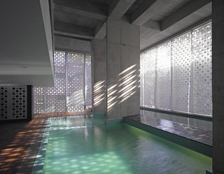 A Modern Aesthetic in Mumbai - Photo 12 of 17 - The aluminum casing creates a play of light and shadows as the sun moves across the building. A lap pool, at right, spills over into the main pool.