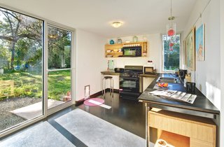 When planning the house as a single man, Wong asked for a "bachelor’s kitchen," noting that he could only make frozen pizza and sandwiches. The simple setup, which faces East and receives the bright morning sun, still accommodates the family well. The little door is shared by Wong’s two Italian greyhounds, Sage and Solo, and the family cat, Coco. As throughout the house, the Low-e doors and windows are from Anchor Ventana. Richlite countertops.