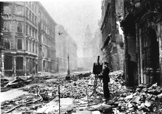 This photograph of Bernard Hailstone painting in Blitz ruins is from the Art Archive / Imperial War Museum / Eileen Tweedy. Courtesy Lapham's Quarterly