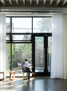 12 Striking Examples of Clerestory Windows in Modern Homes - Photo 5 of 12 - In the house’s front room Kent Monkman relaxes on a stool from local retailer Andrew Richard Designs. A new window system draws in sunlight and views of the front courtyard designed by local landscape architect Terry McGlade, the building’s former owner.