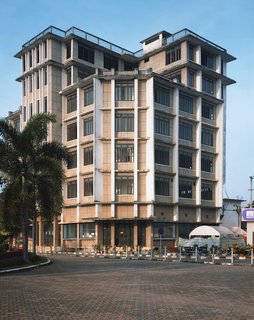 Living in Laos - Photo 4 of 14 - For a long time this building was the tallest building in Vientiane. I love the way it shoots straight up and out with those lines accentuating its verticality. That must have been quiet a terrace up on top in its heyday. It was probably built in the 1950s and housed the French Cultural Center back when the French were in control of the country. Apparently the members of the family who own it cannot come to any agreement and the building has been vacant for many years—except for one shop on the first floor.