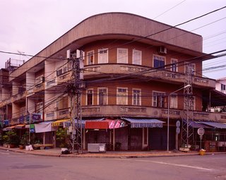 Living in Laos - Photo 9 of 14 - This building is in the old Chinese area of Vientiane, Ban Haysok, near the Mekong River and close to the old center of town. Probably built in the 1960’s. At night this area is filled with street vendors selling noodles, Lao/Chinese desserts and other goodies. In the morning it is quiet and I felt the light on this particular morning really brought out the sensual lines of the building.