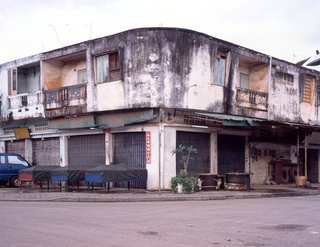 Living in Laos - Photo 1 of 14 - This building is located in Ban Kuanluang Neua, the neighborhood where recent Chinese immigrants have settled, near the evening market of Thong Khan Kham. It's a bustling commercial center. To get this shot I literally had to set up the tripod inside a store selling machinery parts. I asked the young couple managing the store, in my barely passable Lao, if it was OK for me to set up the tripod. Their blank expression immediately told me they weren’t Lao. Officials estimate this village to be made up of two thirds foreign-born residents—mostly Chinese but also Vietnamese and Thai.