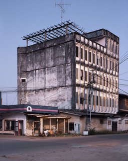 Living in Laos - Photo 12 of 14 - It almost seems as if at some point it had been a triangular building with the gas station under it. I love the way it just sits on top of the small house, the wooden lattice work on the roof mirroring the patterns of the framing of the windows. My guess is that it was built in the 1960s.