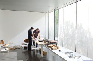 Atherton and Keener review architectural drawings in their "living room," which also serves as a work studio and performance space.