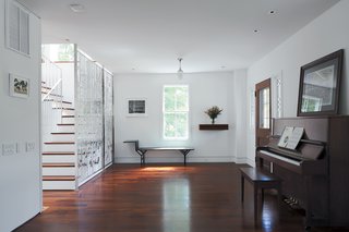 Combining old and new, Renaldi and Boyd placed the <br><br>latter’s family piano and a painted metal Jean Prouvé bench in <br><br>the entryway, each a fine counterpoint to the filigree of Magnes’s screen.