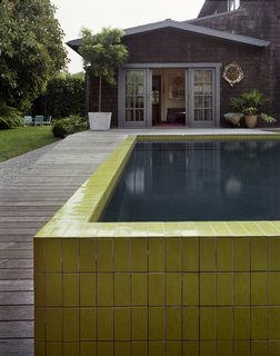 The wall that wraps around the sunken pool was completed—like the seeded concrete pathway—with painstaking precision. The tiles were custom designed with Mission Tile West to hit a pea-green hue and sized specifically to top the narrow walls.