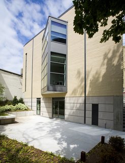 In the rear, triangular window bay juts from the building's main mass.