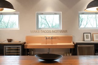 In the kitchen, Make Tacos Not War, by San Antonio-based artist Alejandro Diaz, is mounted over a putty-colored sink Hill Salvaged from a demolition yard.
