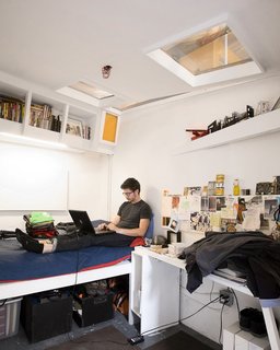 Justin Smith’s cell-like quarters are packed full of books and art. "Each room gets the bare minimum: a sleeping area, a desk, and storage," explains Ionescu. The designers carefully laid out the space so that the beds in each room are as far apart from each other in plan as possible, in order to get as much privacy as possible.