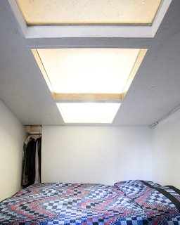 A "Mohawk" skylight cuts across the ceiling of Dreitlein's room. The interior skylights bring in extra light and help the cell-like rooms feel more spacious.