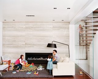 When the Hsus found themselves expecting a third child, they engaged Lang to enclose the upper part of their double-height living room to create a fourth bedroom and playroom-study upstairs. Additionally, Lang resurfaced the fireplace wall with massive slabs of filled silver travertine marble. The slabs were so large that one of them broke an adjoining floor-to-ceiling glass pane during installation.