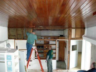 One of the major changes to the house when it was rebuilt in 1950 was the raised height of the kitchen wall. "Extending the wall up disguised the line of the butterfly ceiling," says Altman. Here, a team of craftsmen commissioned by the RBF works on deconstructing the upper portion of a non-lode bearing wall separating the kitchen from the living room. Photo courtesy of the Rockefeller Brothers Fund.