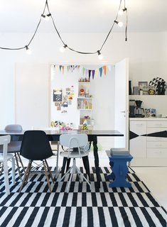The family's activity centers around the open-plan dining room, which does triple-duty as a living room and kitchen. Susanna prefers a motley set of dining chairs over a coordinated set; that way guests can pick their favorite when they sit.