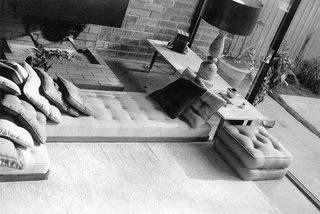 Frank told us how he took off the legs of a couch and put it on the floor next to the fireplace. We can also see in this image that the paver in the courtyard used to be about a foot larger than it is today.