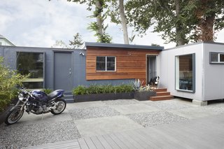 Shoup built a connector between the shipping containers and covered it with salvaged redwood. Glass panels from old sliding doors offer ample illumination in the workspaces. Photo by Muffy Kibbey.