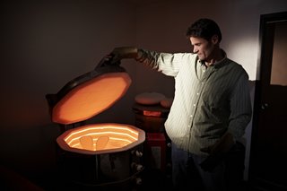 Wisner can judge the temperature inside his kiln by the color of the clay as it’s firing.