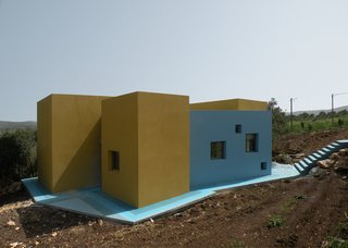 The house sits on a slope, atop blue concrete and ceramic tiles. A set of web-shaped stairs (right) flow like a waterfall onto the blue floor.<br><br>Photo courtesy <br><br>Z-A Studio.