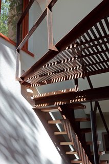 In the second-floor hallway, Bernier skipped typical hardwood flooring in favor of thin strips of birch boards spaced a distance apart to allow light to filter between the two levels.